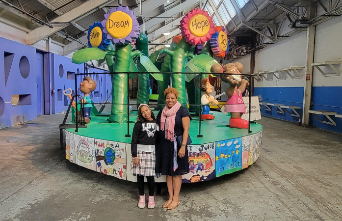  student and staff in front of parade